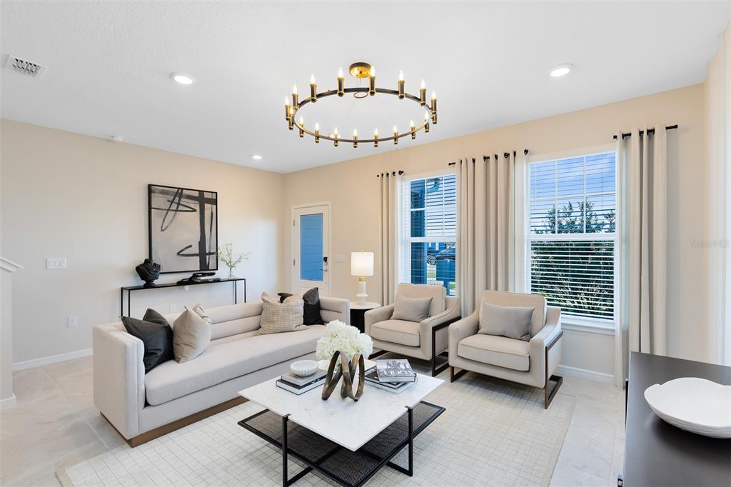 A living room features a light-colored sofa, two armchairs, a marble coffee table, and chandelier — 11571 HARBORVIEW STREET, ORLANDO, FL