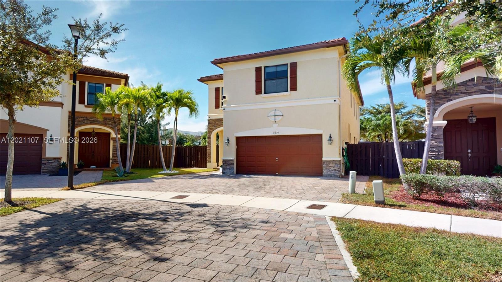 A two-story house with a brown garage door and palm trees in the front yard — 8610 NW 101st Pl, Doral FL 33178, DORAL, FL