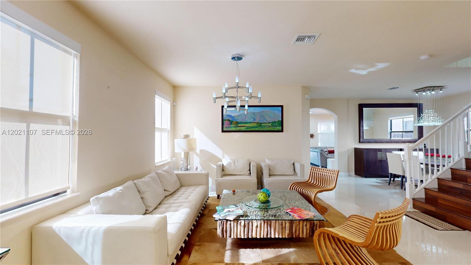 A living room features a white sofa, two armchairs, a wooden coffee table, and stairs — 8610 NW 101st Pl, Doral FL 33178, DORAL, FL