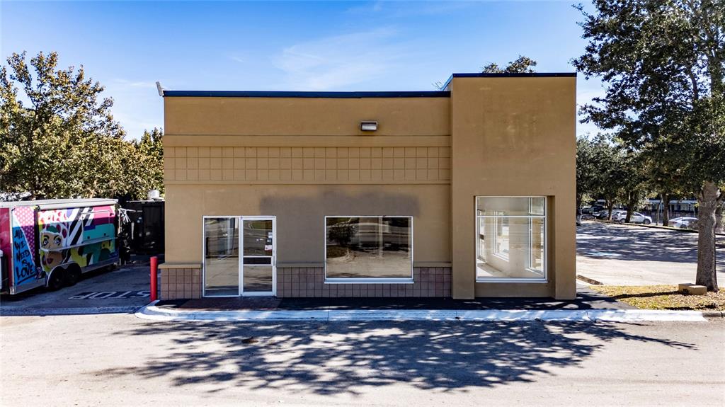 A tan, single-story commercial building with a glass door and two large windows — 7155 S ORANGE BLOSSOM TRAIL, ORLANDO, FL