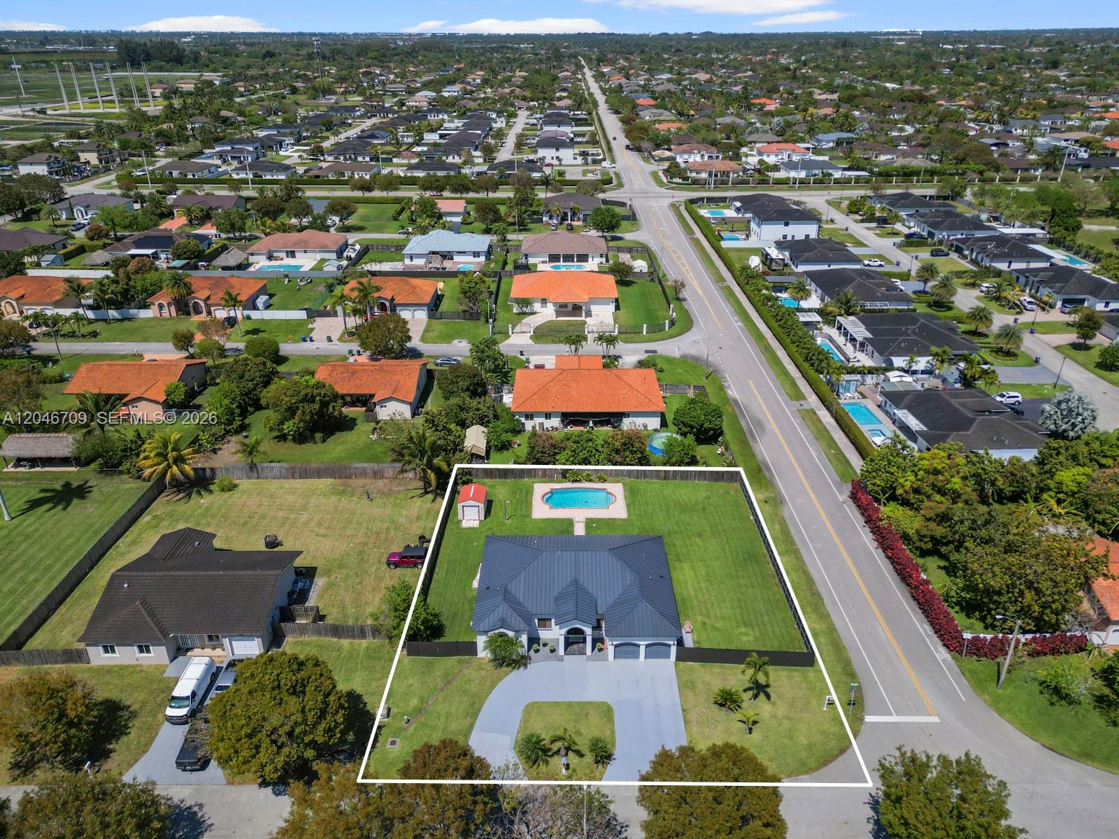 An aerial view shows a single-story house with a dark roof, pool, and fenced yard — 13205 SW 218th Ter, Miami FL 33170, MIAMI, FL