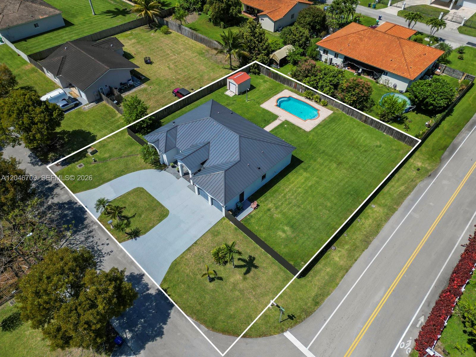 An aerial view shows a single-story house with a metal roof, pool, and fenced yard — 13205 SW 218th Ter, Miami FL 33170, MIAMI, FL