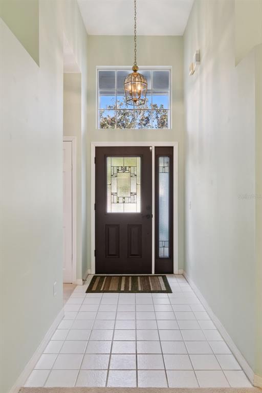A tiled entryway features a dark front door with glass panels and a hanging lantern light — 2615 BURWOOD AVENUE, ORLANDO, FL