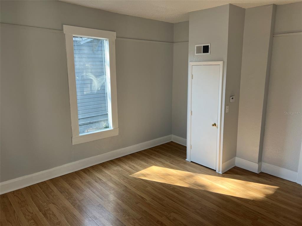 A room with light gray walls, hardwood flooring, a window, and a small closet door — 901 PENNSYLVANIA AVENUE UNIT 1, LAKELAND, FL