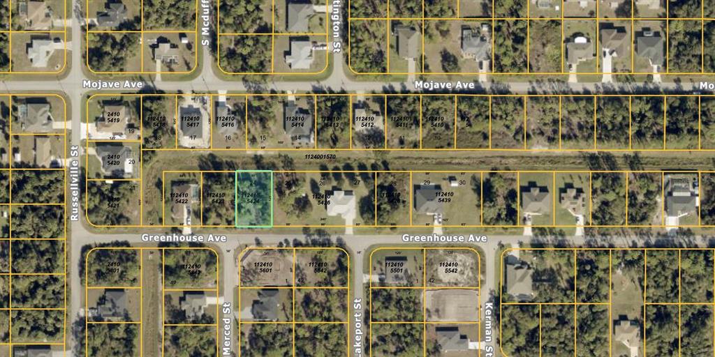 This is an aerial map showing a vacant residential lot highlighted in green among other properties — GREENHOUSE AVENUE, NORTH PORT, FL