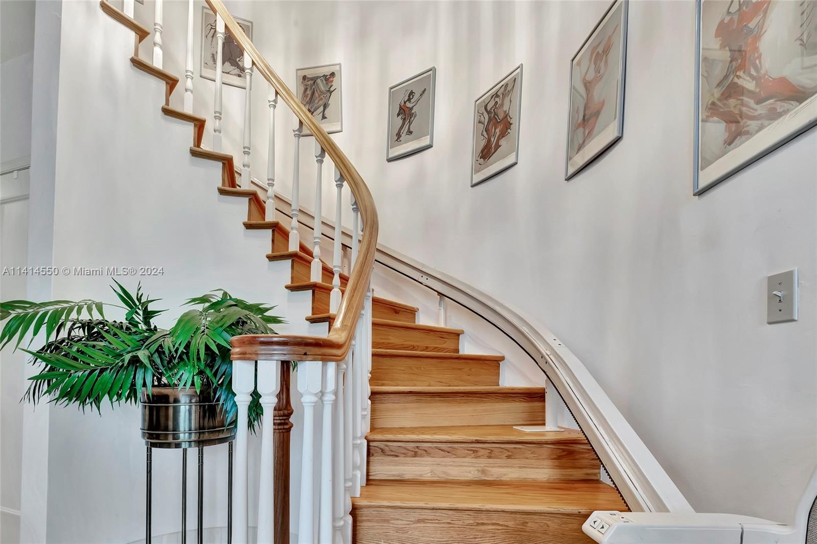 A curved wooden staircase with a white railing and a mounted stairlift — 4716 University Dr, Coral Gables FL 33146, CORAL GABLES, FL