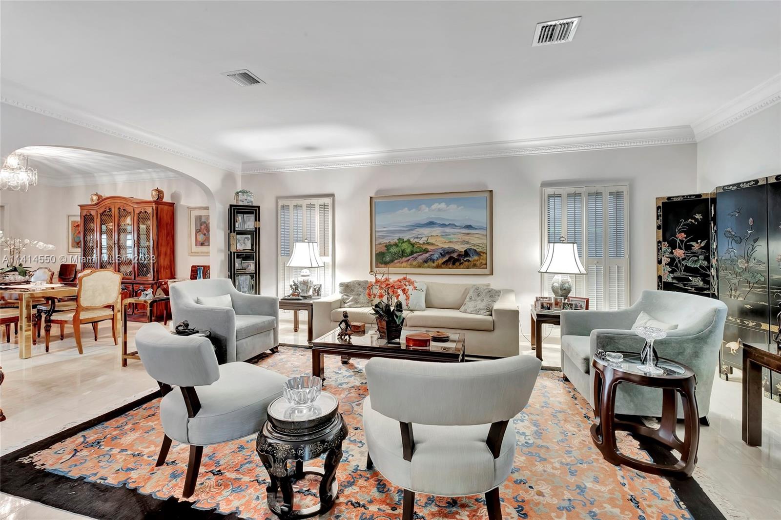 A living room features light-colored furniture, a patterned area rug, and a large landscape painting — 4716 University Dr, Coral Gables FL 33146, CORAL GABLES, FL