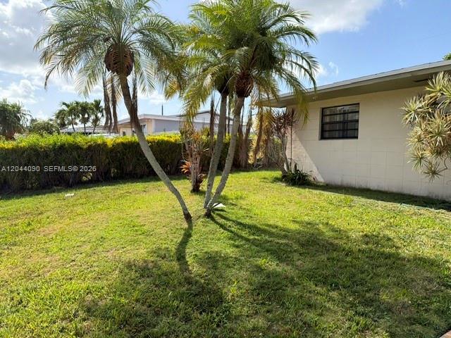 A grassy backyard features two palm trees next to the side of a beige house — 11832 SW 185th Ter, Miami FL 33177, MIAMI, FL