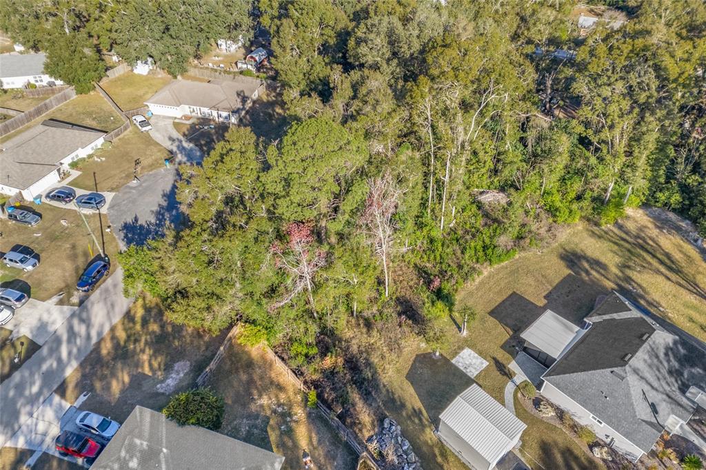 An aerial view shows a wooded lot situated between several suburban houses and driveways — 00 NW 236TH WAY, HIGH SPRINGS, FL