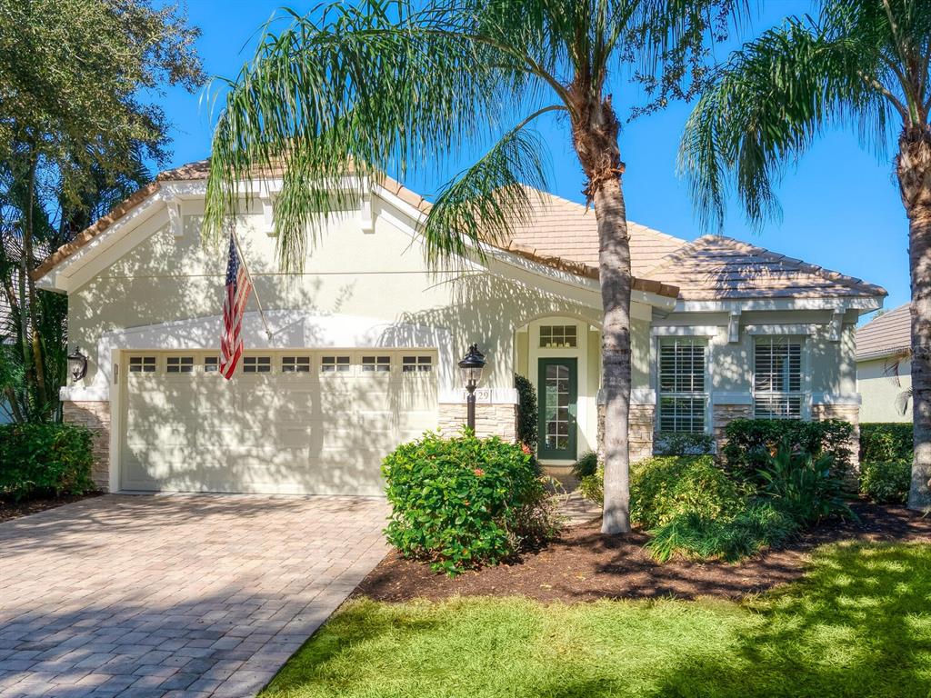 An open-concept living area features a grand piano, hardwood floors, and a modern kitchen — 12129 THORNHILL COURT, LAKEWOOD RANCH, FL