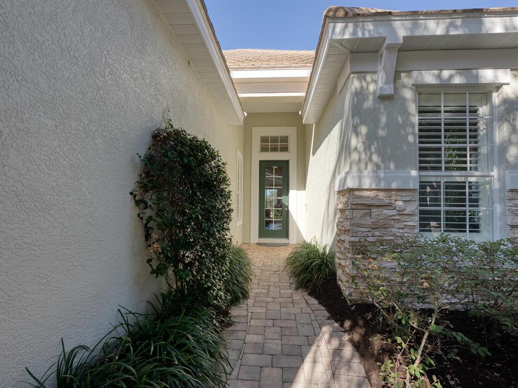 A black grand piano sits in a bright room with white walls and wood flooring — 12129 THORNHILL COURT, LAKEWOOD RANCH, FL