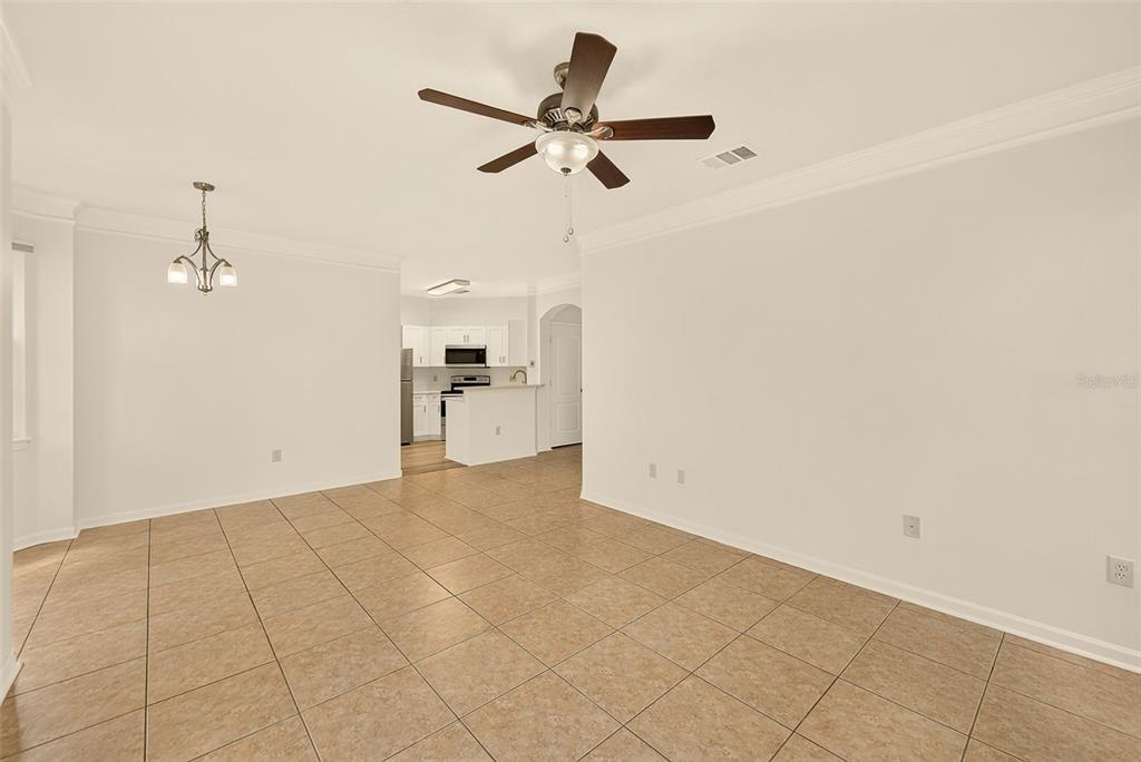 A spacious, tiled living area with a ceiling fan opens into a white kitchen — 18138 VILLA CREEK DRIVE UNIT 18138, TAMPA, FL