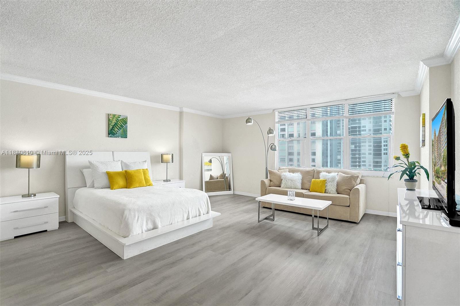 A studio apartment features a bed, sofa, coffee table, and light-colored wood-look flooring — 2501 S Ocean Dr, Hollywood FL 33019, HOLLYWOOD, FL