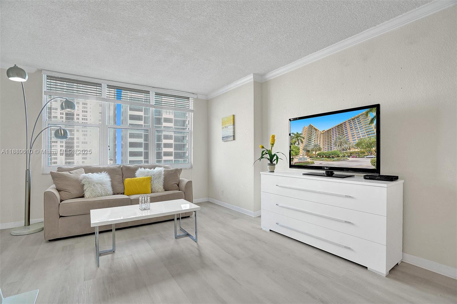 A living room features a beige sofa, white coffee table, and a white media console — 2501 S Ocean Dr, Hollywood FL 33019, HOLLYWOOD, FL