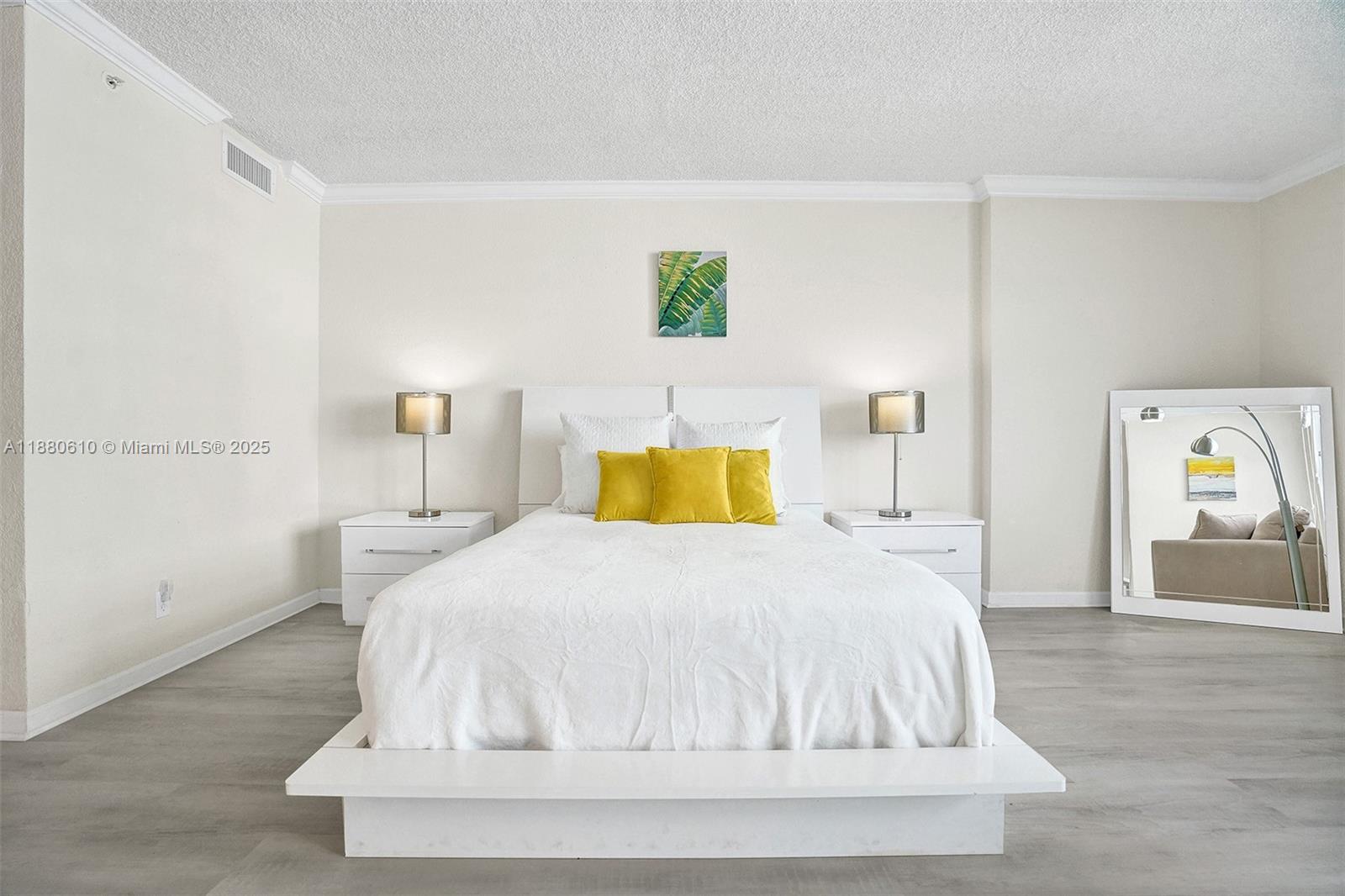 A bedroom features a white platform bed, two nightstands with lamps, and a floor mirror — 2501 S Ocean Dr, Hollywood FL 33019, HOLLYWOOD, FL
