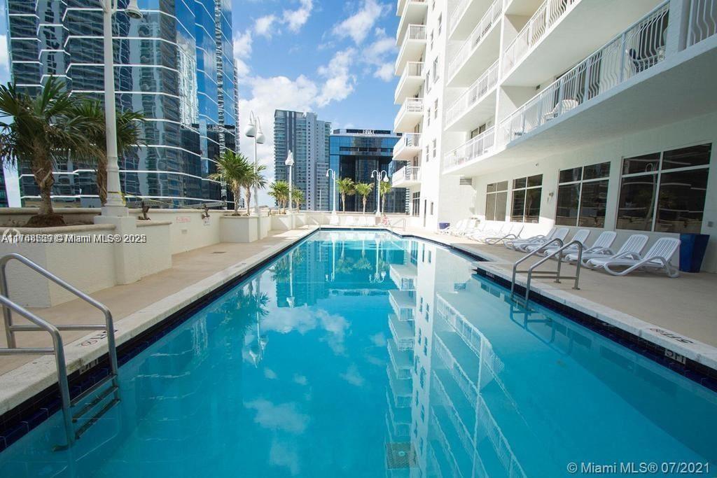 A rectangular swimming pool is situated on a terrace between two tall buildings — 1200 Brickell Bay Dr # 3924, Miami FL 33131, MIAMI, FL