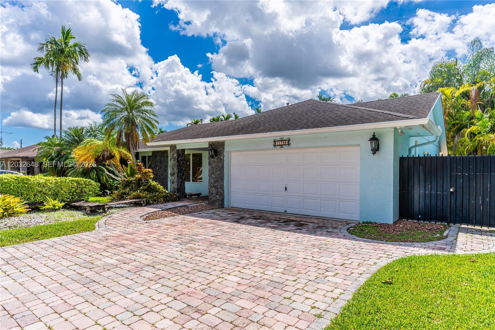 A single-story house with a light blue exterior, stone accents, and a brick paver driveway — 11728 SW 97th St # 0, Miami FL 33186, MIAMI, FL