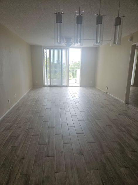A living room features light wood-look tile flooring, four pendant lights, and a sliding door — 1421 S Ocean Boulevard # 412, Pompano Beach FL 33062, POMPANO BEACH, FL