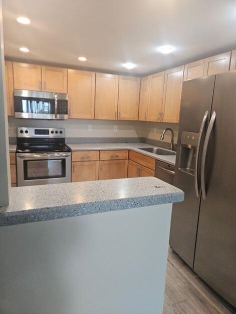 A kitchen features light wood cabinets, stainless steel appliances, and a speckled gray countertop — 1421 S Ocean Boulevard # 412, Pompano Beach FL 33062, POMPANO BEACH, FL