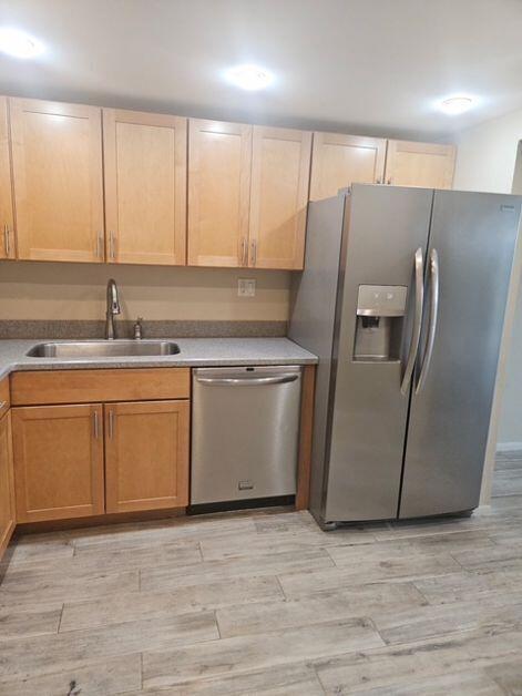 A kitchen features light wood cabinets, stainless steel appliances, and gray wood-look tile flooring — 1421 S Ocean Boulevard # 412, Pompano Beach FL 33062, POMPANO BEACH, FL