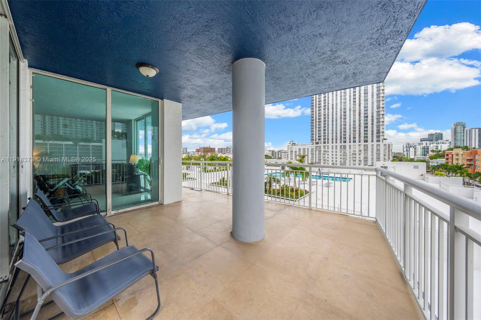 A balcony with a blue ceiling, a central support column, and a view of buildings — 275 NE 18th St # 708, Miami FL 33132, MIAMI, FL