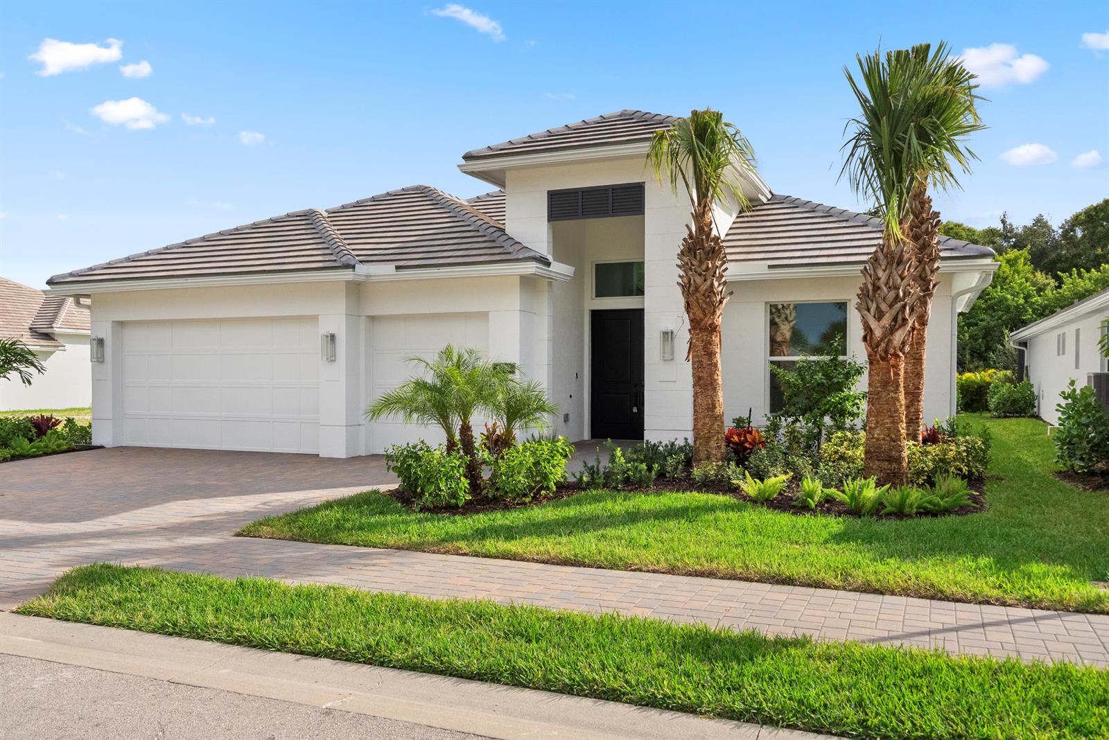 A single-story white house with a tile roof, two-car garage, and two palm trees — 4237 Lucaya Pointe Way, Vero Beach FL 32967, VERO BEACH, FL