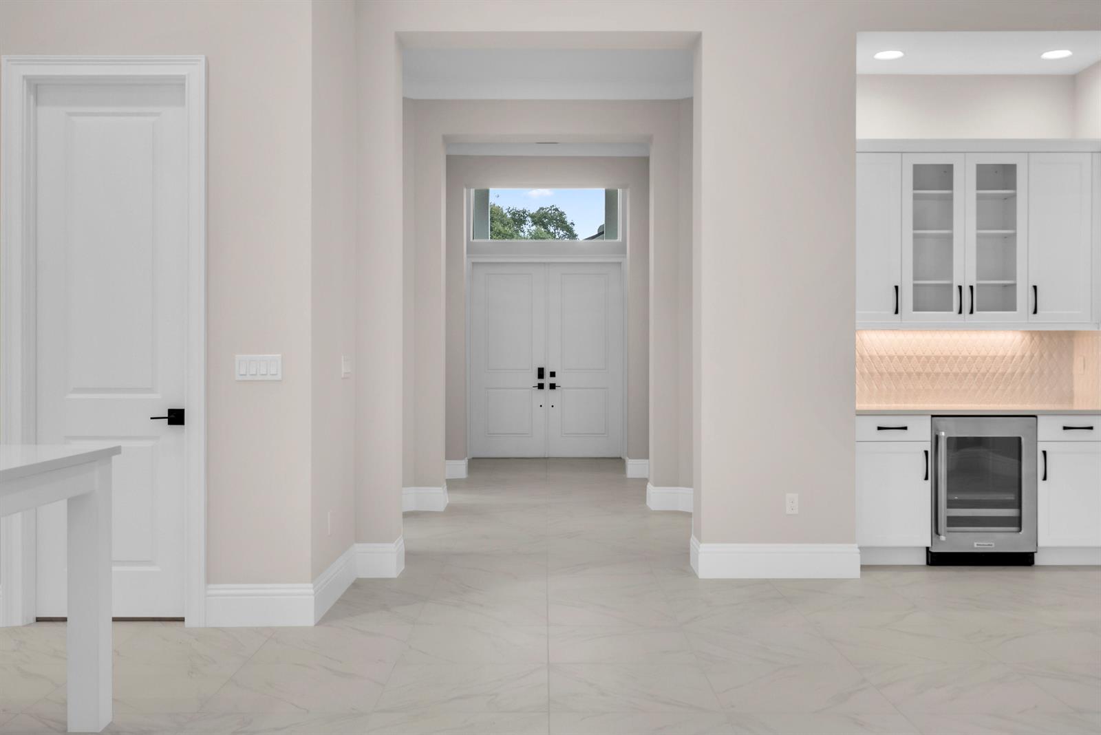A bright entryway features white double doors, light tile flooring, and a nearby wet bar — 4237 Lucaya Pointe Way, Vero Beach FL 32967, VERO BEACH, FL