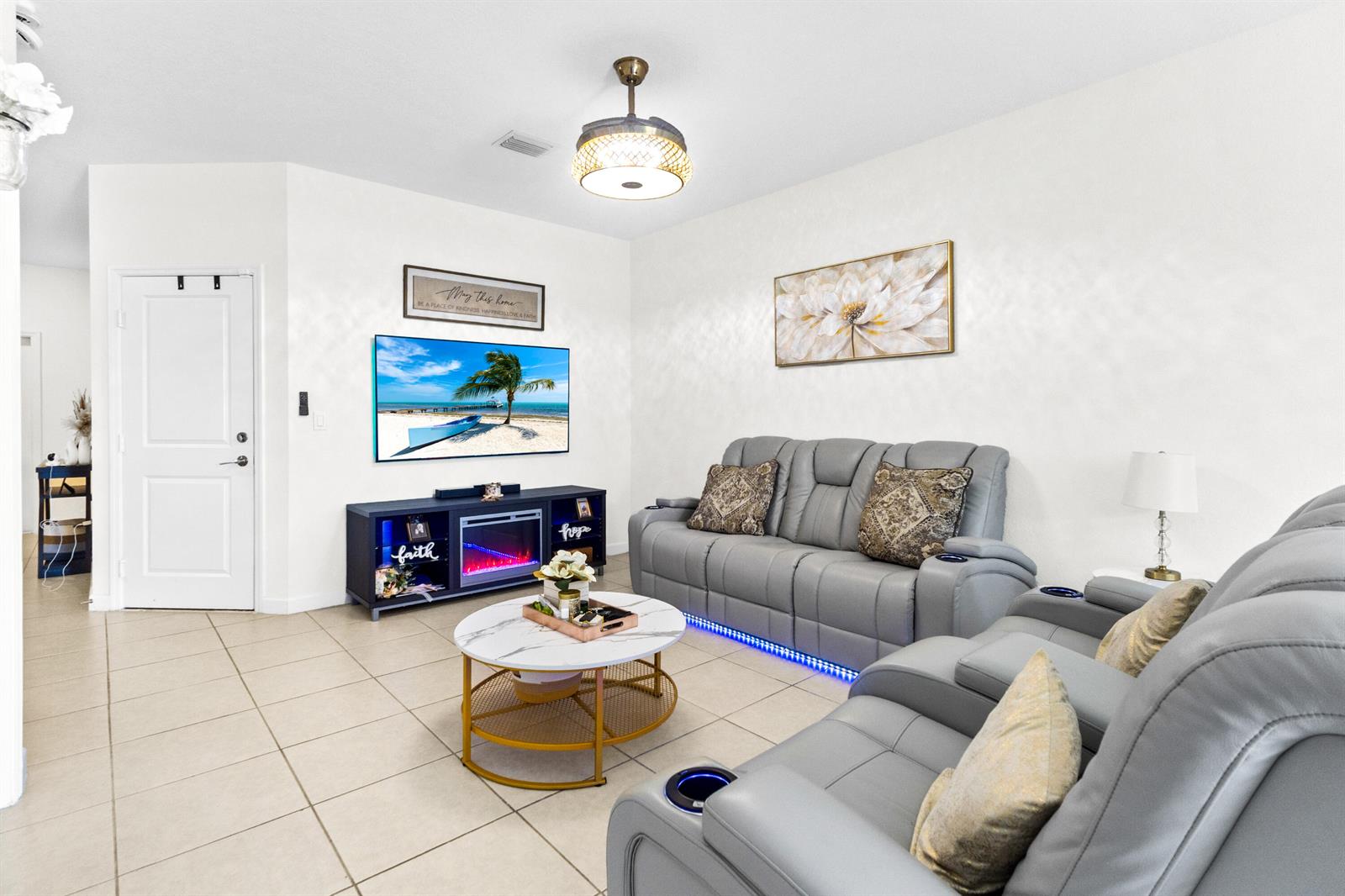 A living room features gray reclining sofas, a marble coffee table, and a fireplace console — 2688 NW 55th Terrace, Lauderhill FL 33313, LAUDERHILL, FL