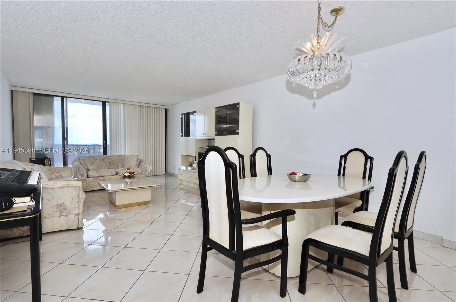 A dining area with a chandelier and table set sits beside a living room — 2401 S Ocean Dr # 806, Hollywood FL 33019, HOLLYWOOD, FL