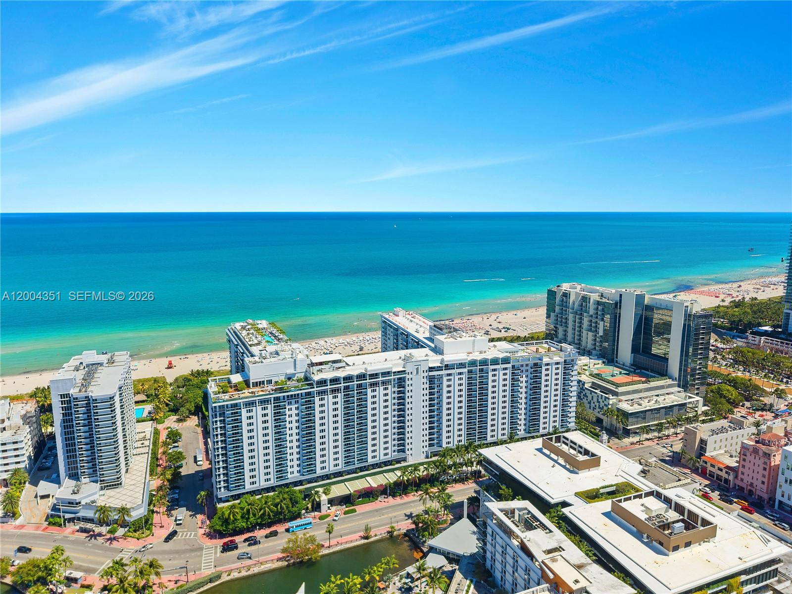 An aerial view shows multiple high-rise buildings situated along a sandy beach and ocean — 2301 Collins Ave # 432, Miami Beach FL 33139, MIAMI BEACH, FL