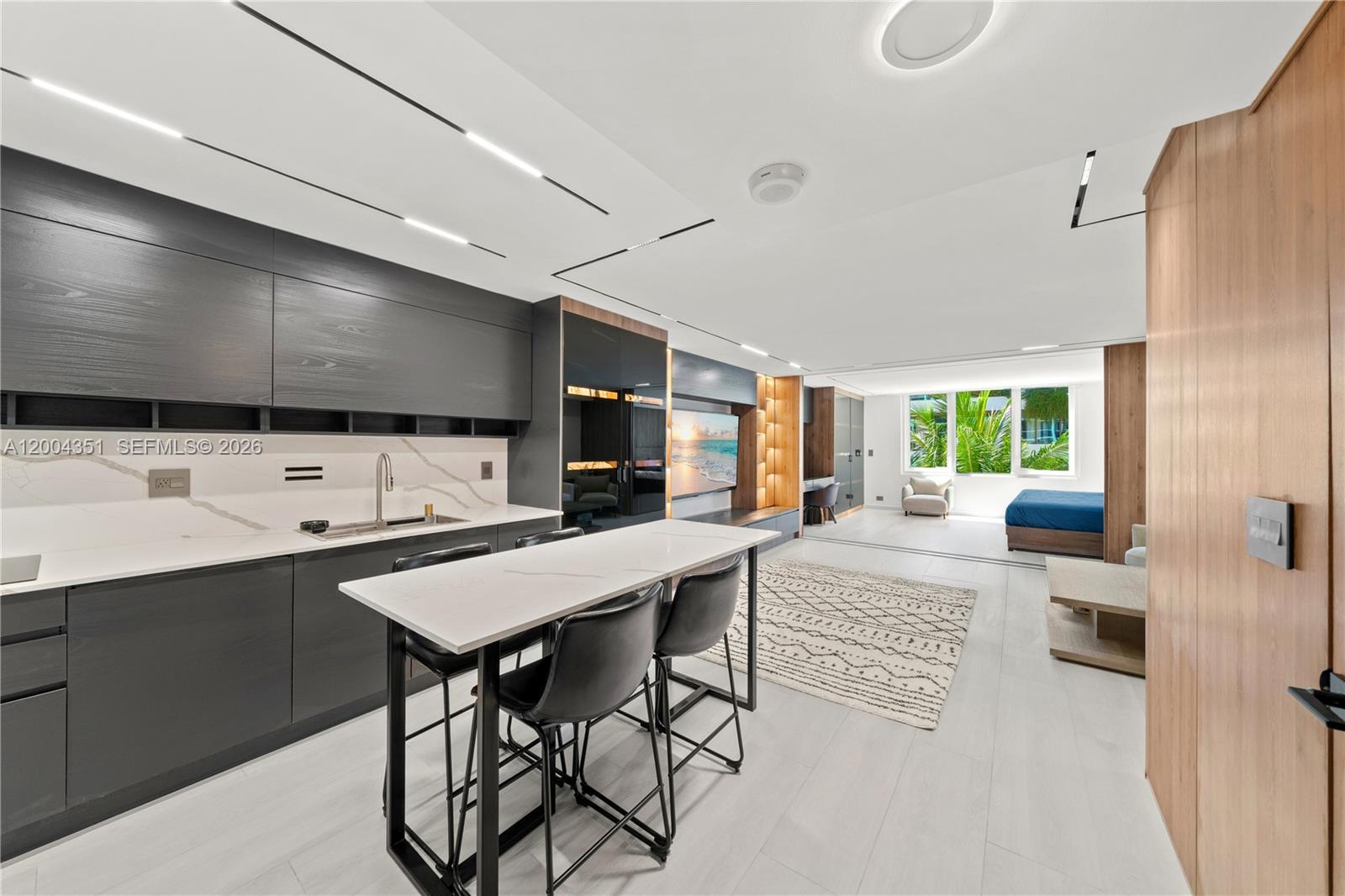 A modern studio apartment features a dark kitchen, a breakfast bar, and a bedroom area — 2301 Collins Ave # 432, Miami Beach FL 33139, MIAMI BEACH, FL