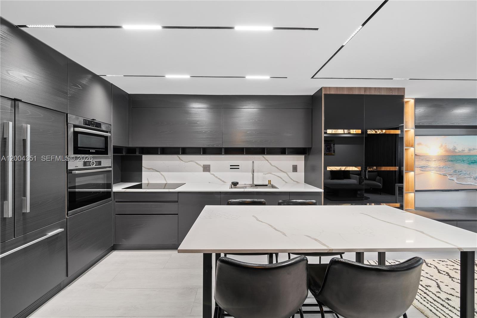 A modern kitchen features dark wood cabinetry, white marble countertops, and a matching island — 2301 Collins Ave # 432, Miami Beach FL 33139, MIAMI BEACH, FL