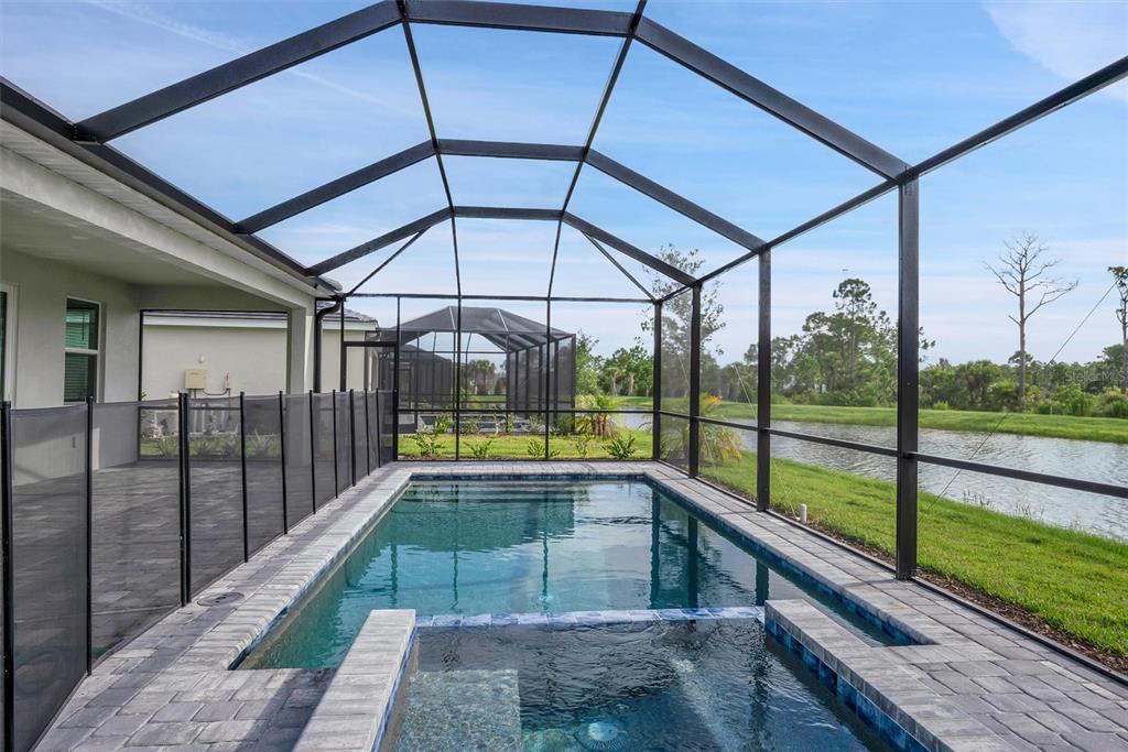 A screened-in pool and spa area with paver decking overlooking a pond — 19100 MOSCATO COURT, VENICE, FL