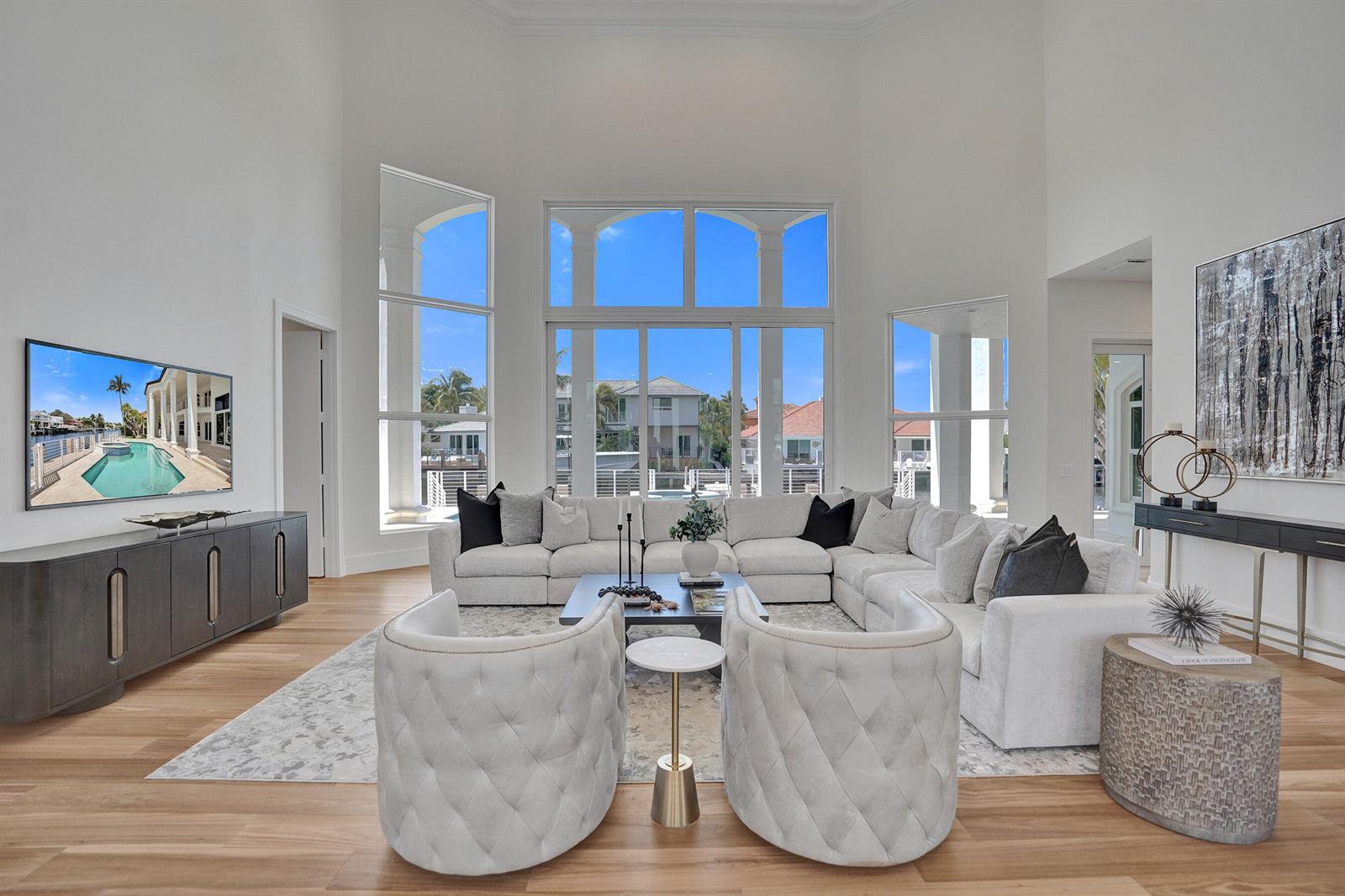 A spacious living room features high ceilings, a large sectional sofa, and floor-to-ceiling windows — 890 Lilac Drive, Boca Raton FL 33487, BOCA RATON, FL