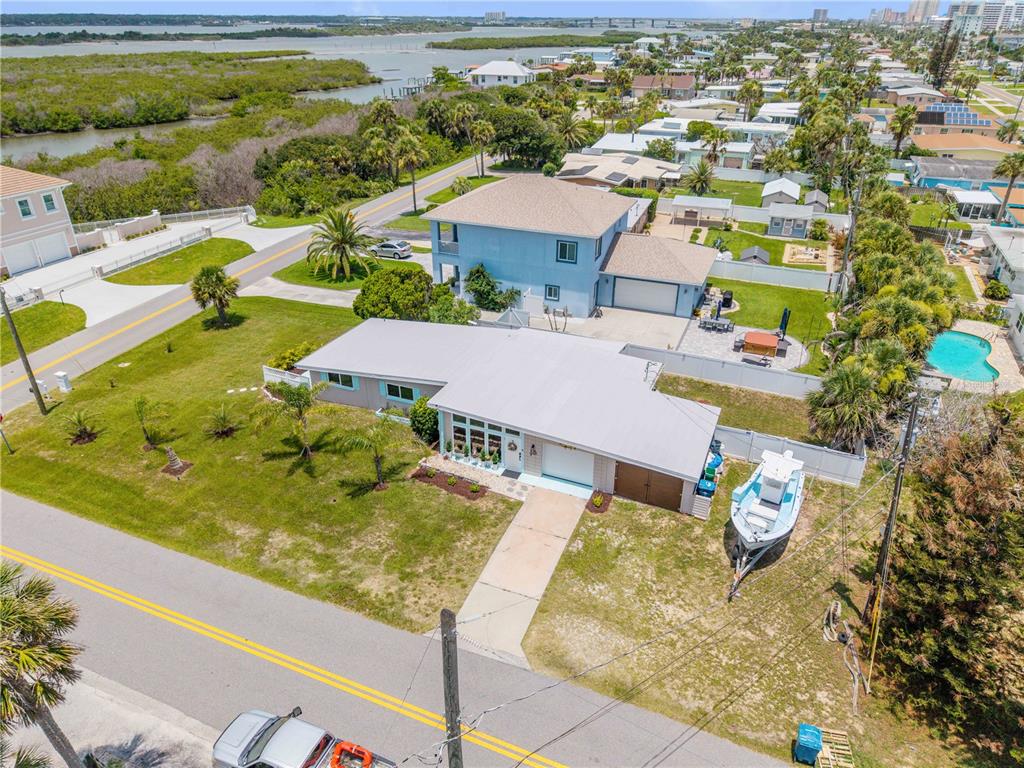 An aerial view shows a single-story house with a boat parked in the side yard — 3929 S PENINSULA DRIVE, PORT ORANGE, FL