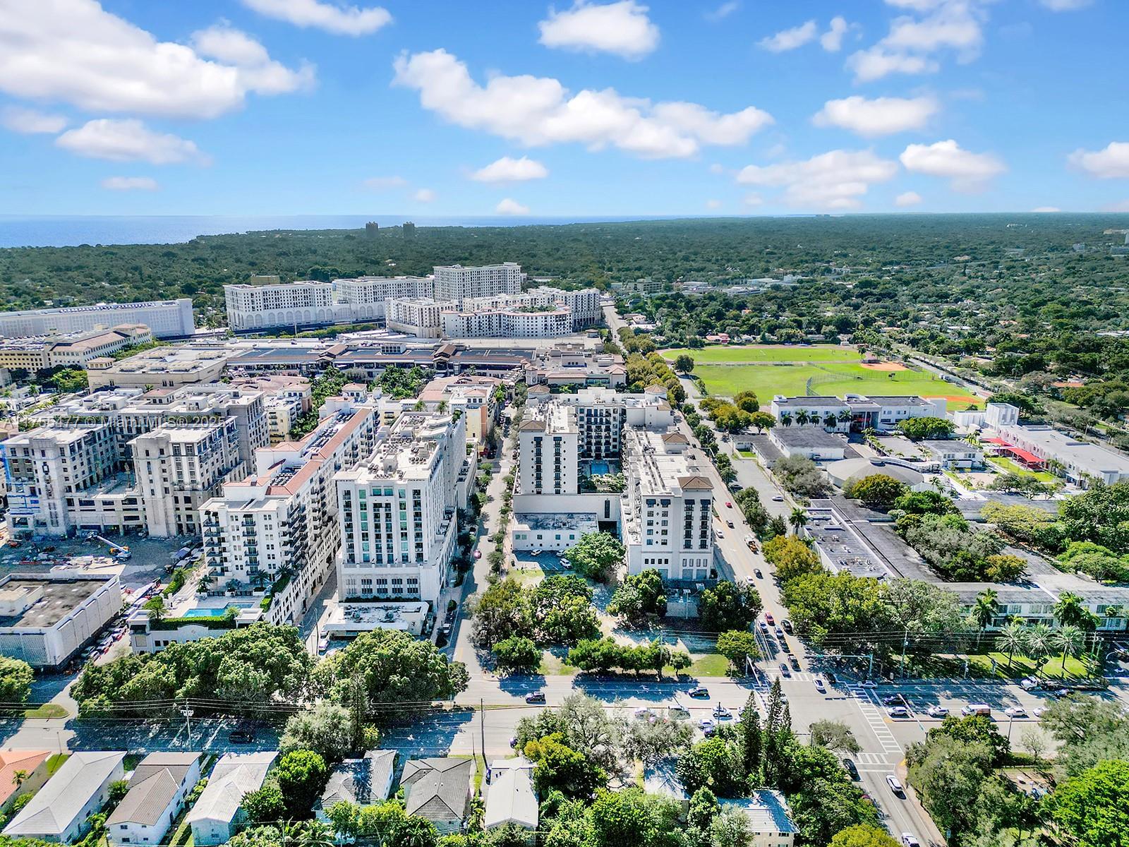An aerial view shows a dense urban neighborhood with multi-story apartment buildings and green spaces — 4070 Laguna St, Coral Gables FL 33146, CORAL GABLES, FL