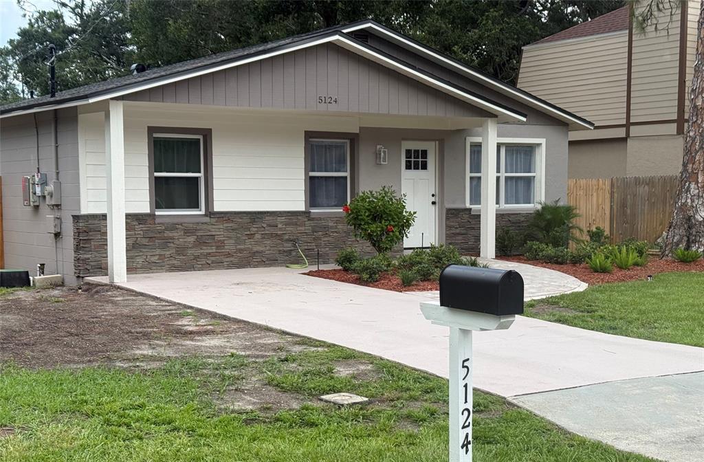 A single-story house features a stone facade, white siding, a paved walkway, and a driveway — 5124 CHILKOOT STREET, TAMPA, FL