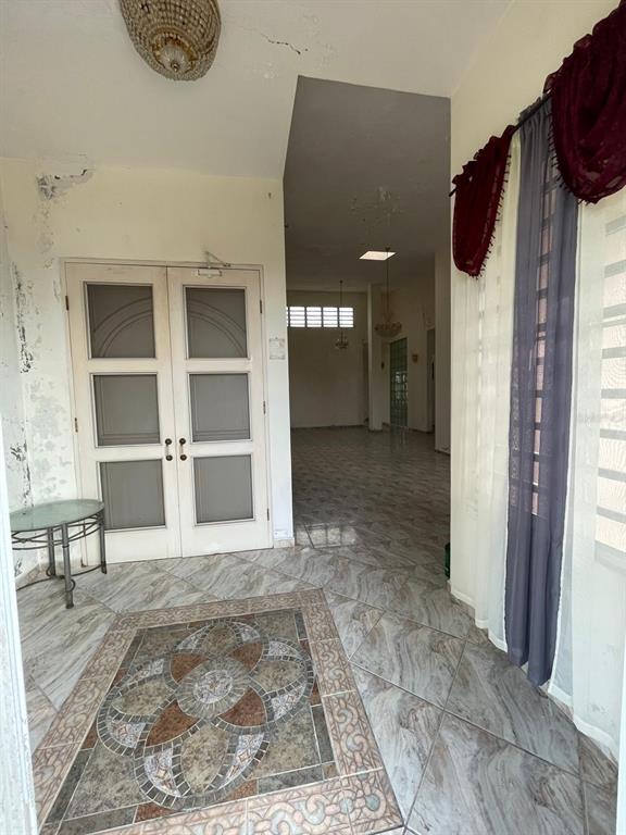 An entryway with tiled floors, a decorative mosaic inlay, and double doors leading inside — PR-115 KM 19.8 INT, AGUADA, PR