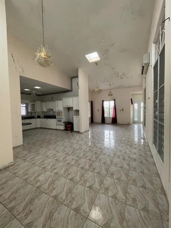 A large, open-concept living and kitchen area features tiled floors and high, vaulted ceilings — PR-115 KM 19.8 INT, AGUADA, PR