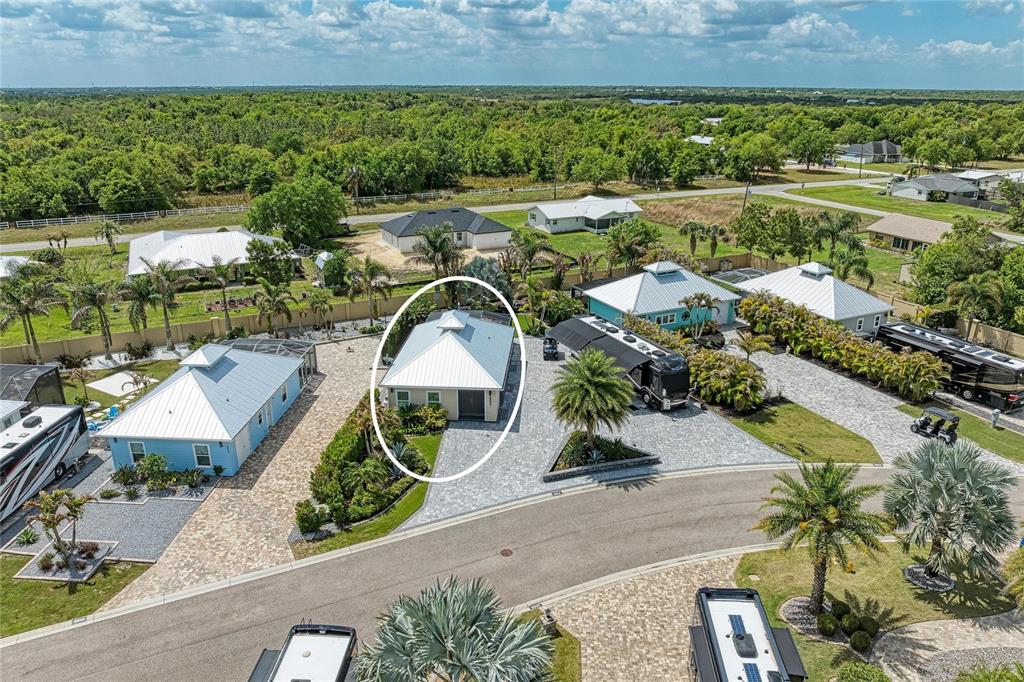An aerial view shows a small house with a white metal roof and paved driveway — 8602 SW SAND CRANE CIRCLE LOT 51, ARCADIA, FL