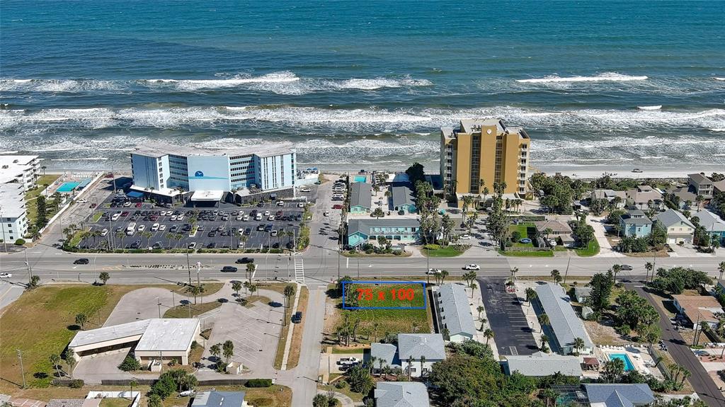An aerial view shows a vacant rectangular lot highlighted in blue near a coastal road — 837 7TH STREET, NEW SMYRNA BEACH, FL