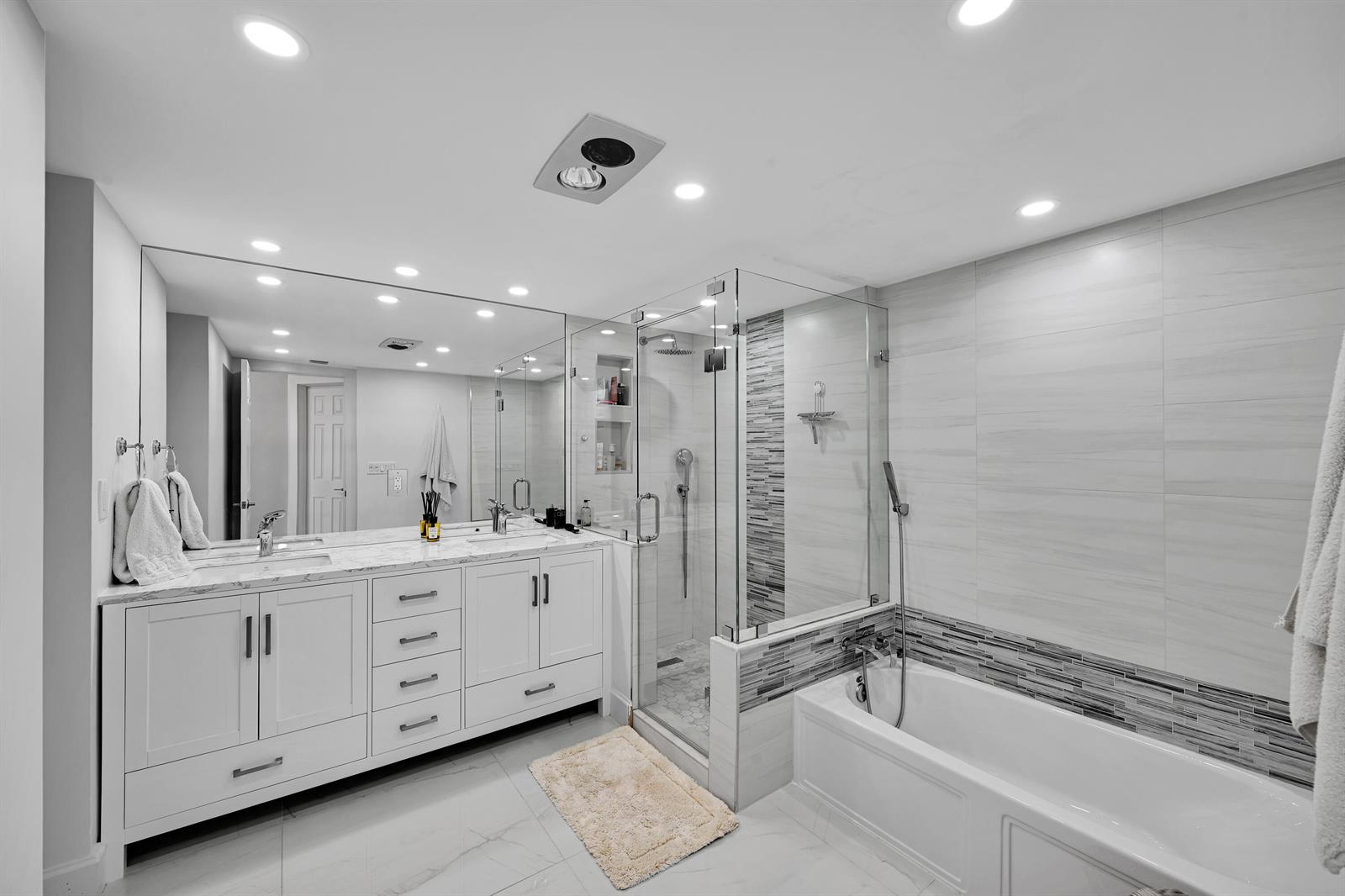 A modern bathroom features a white double vanity, a glass-enclosed shower, and a soaking tub — 3300 S Ocean Boulevard # 306n, Palm Beach FL 33480, PALM BEACH, FL