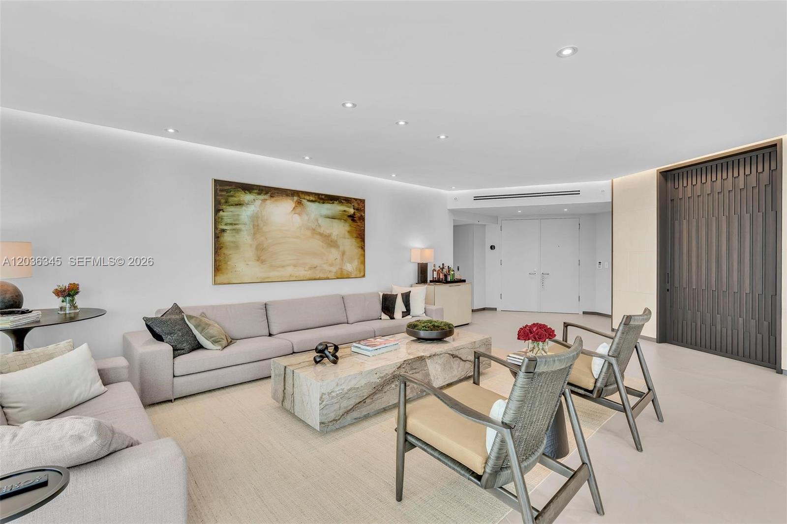 A modern living room features a large sectional sofa, stone coffee table, and two armchairs — 2127 Brickell Ave # 1002, Miami FL 33129, MIAMI, FL