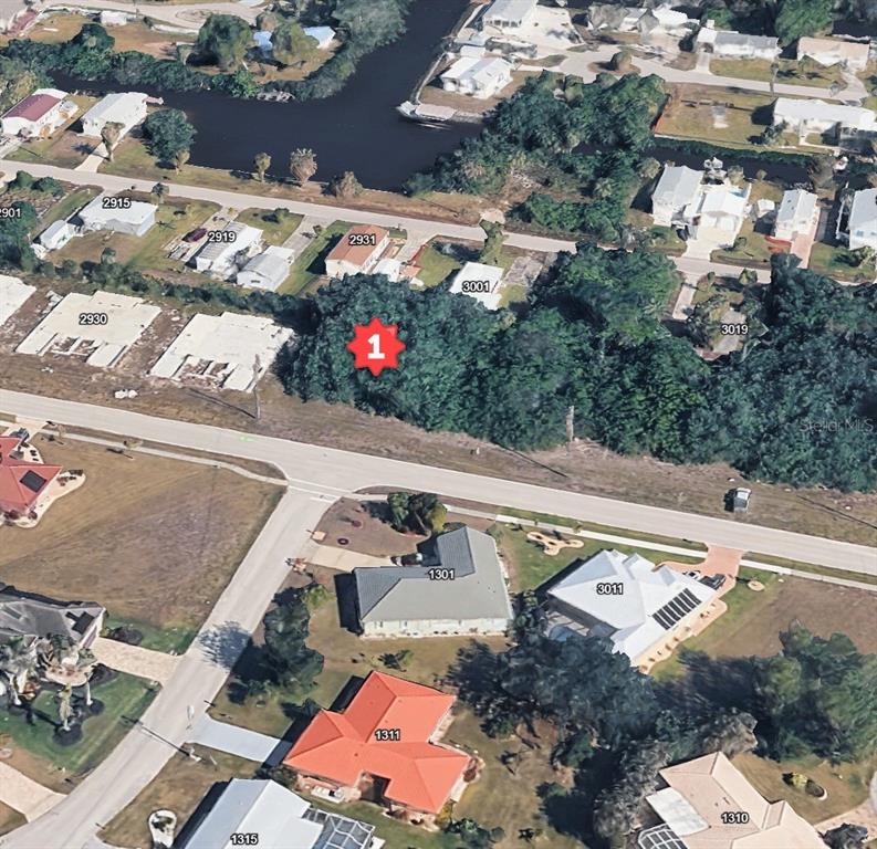 This aerial view shows a vacant, wooded lot marked with a red number one — 2942 MAGDALINA DRIVE, PUNTA GORDA, FL