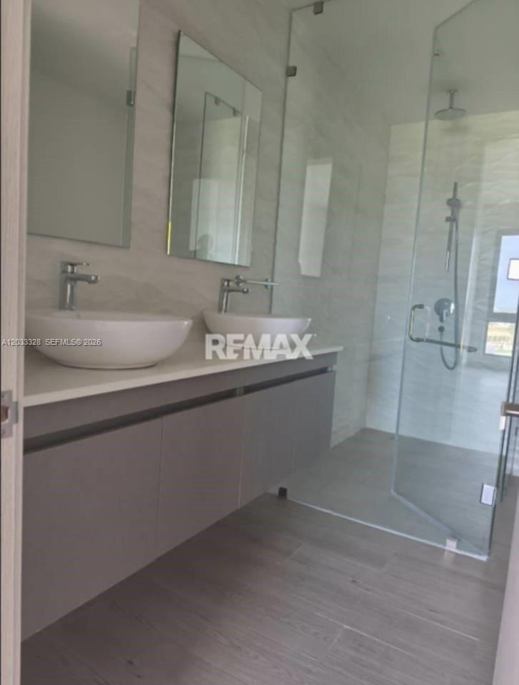 A modern bathroom features a double vanity with vessel sinks and a glass-enclosed walk-in shower — 1 Cap Cana # 1, FL, FL