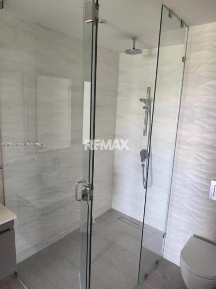A modern bathroom features a glass-enclosed walk-in shower with textured white wall tiles — 1 Cap Cana # 1, FL, FL