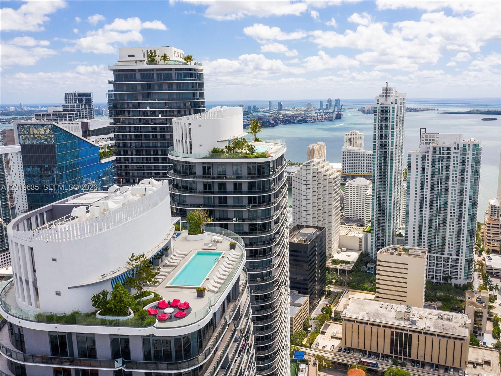 An aerial view shows multiple high-rise apartment buildings with rooftop pools and terraces in Miami — 55 SW 9th St # 1810, Miami FL 33130, MIAMI, FL