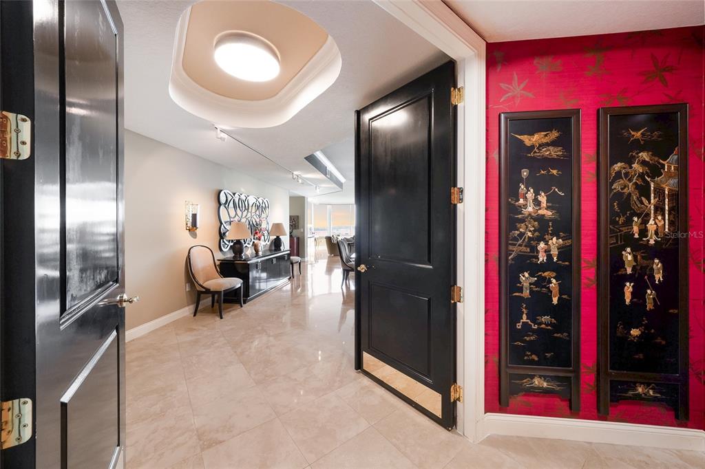 An entryway features black doors, a recessed ceiling light, and red wallpaper with decorative panels — 136 GOLDEN GATE POINT UNIT 602, SARASOTA, FL