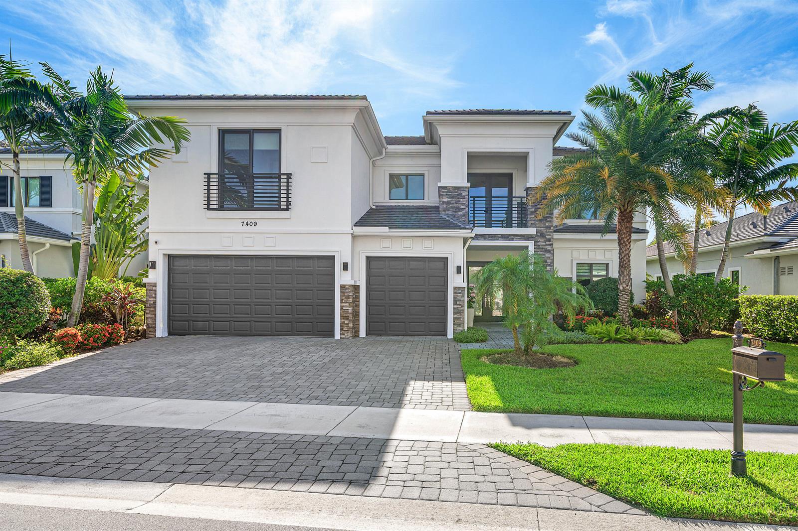 A two-story house with a paved driveway, two garage doors, and a landscaped front yard — 7409 NW 25th Terrace, Boca Raton FL 33496, BOCA RATON, FL