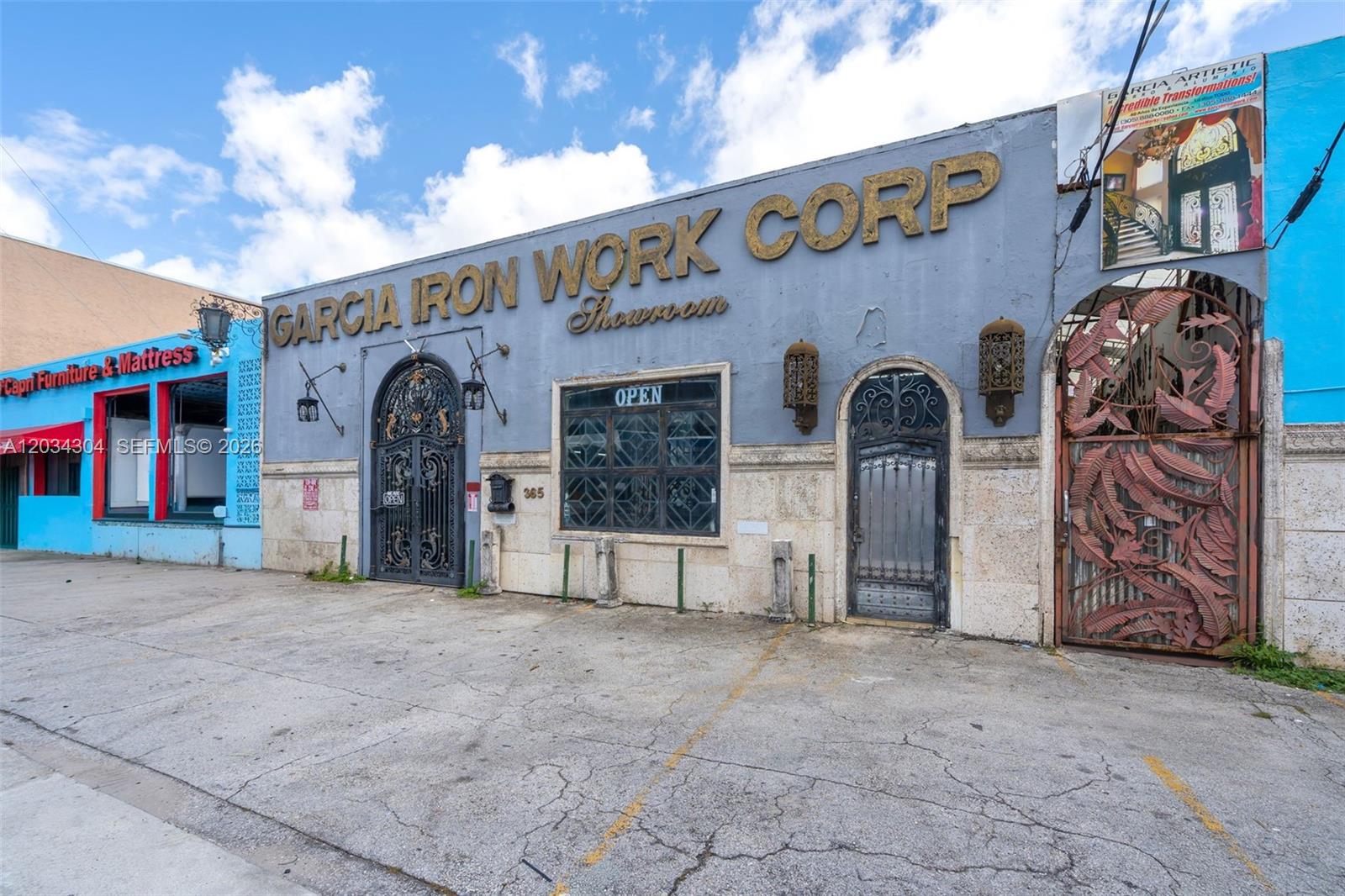 The exterior of a commercial building features ornate iron doors, large signage, and a parking area — 341 W 21st St, Hialeah FL 33010, HIALEAH, FL